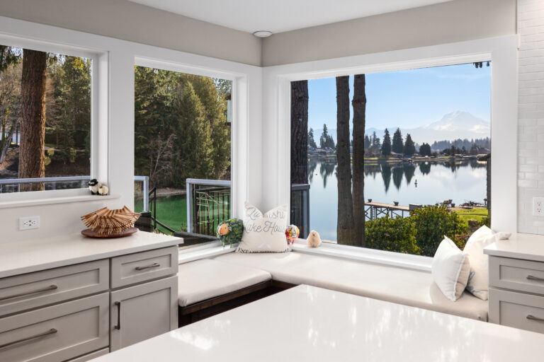 Corner window seat with lake and Mount Rainier views beside gray shaker cabinets and quartz counters