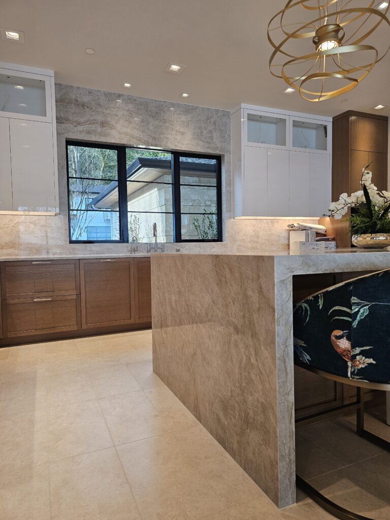 Mitred waterfall corner of the quartzite island beside a floral upholstered counter stool