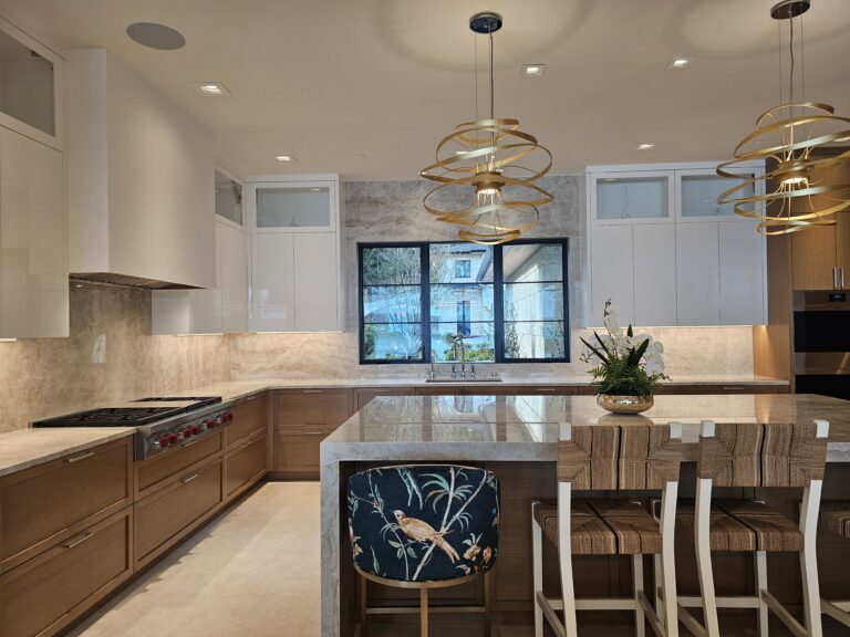 Long quartzite island with waterfall ends, floral stools, and oak oven cabinets in the background