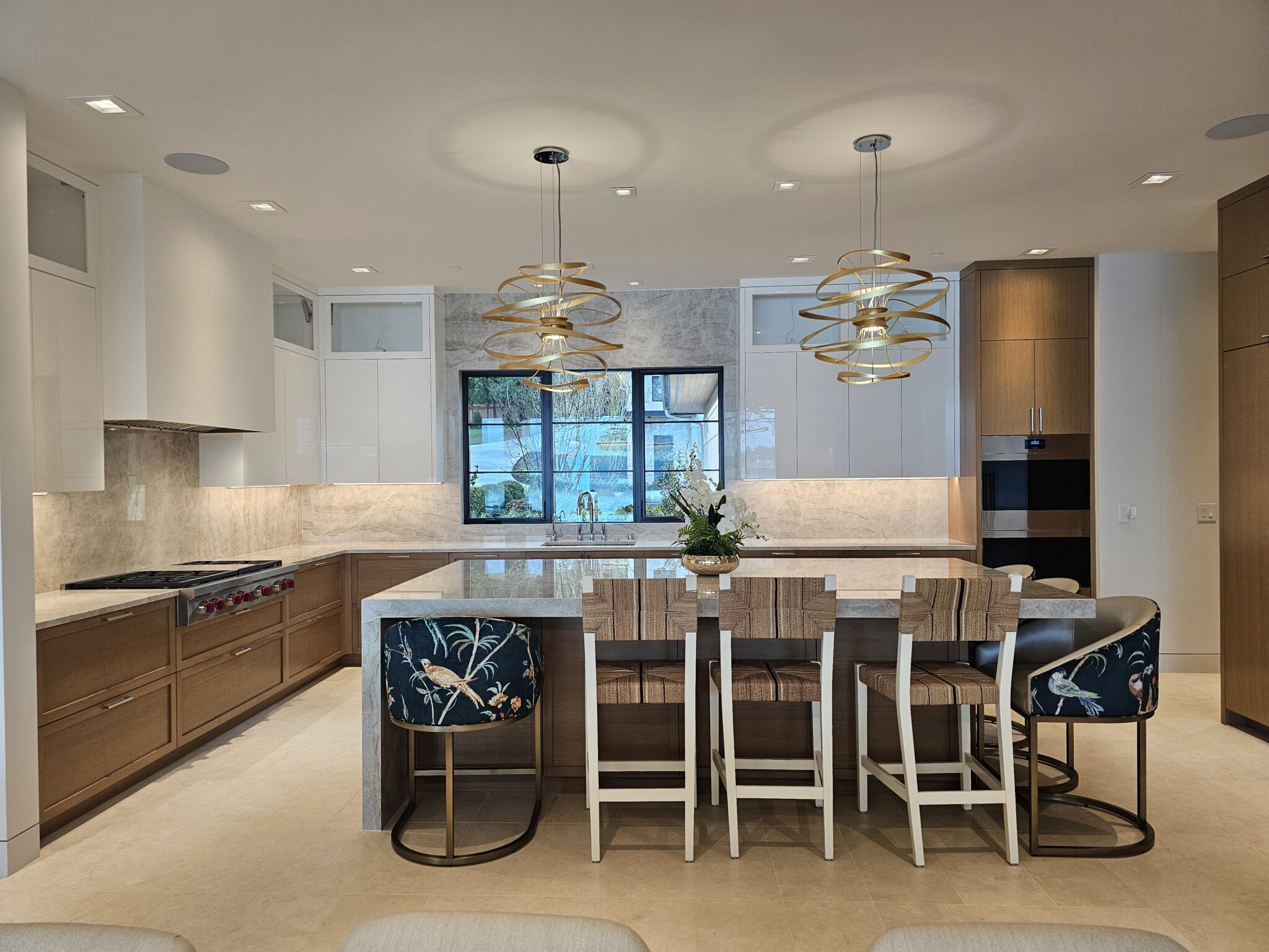 Full kitchen view with quartzite island seating and matching stone backsplash on both walls