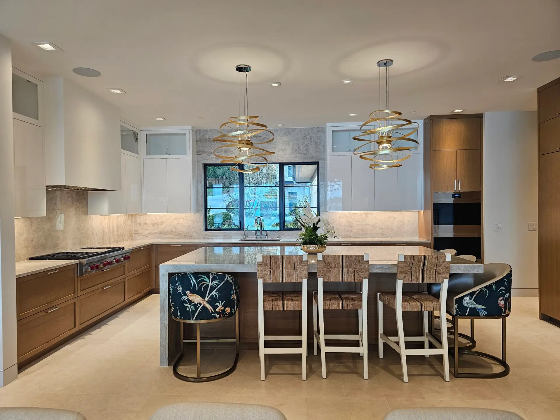 Full kitchen view with quartzite island seating and matching stone backsplash on both walls