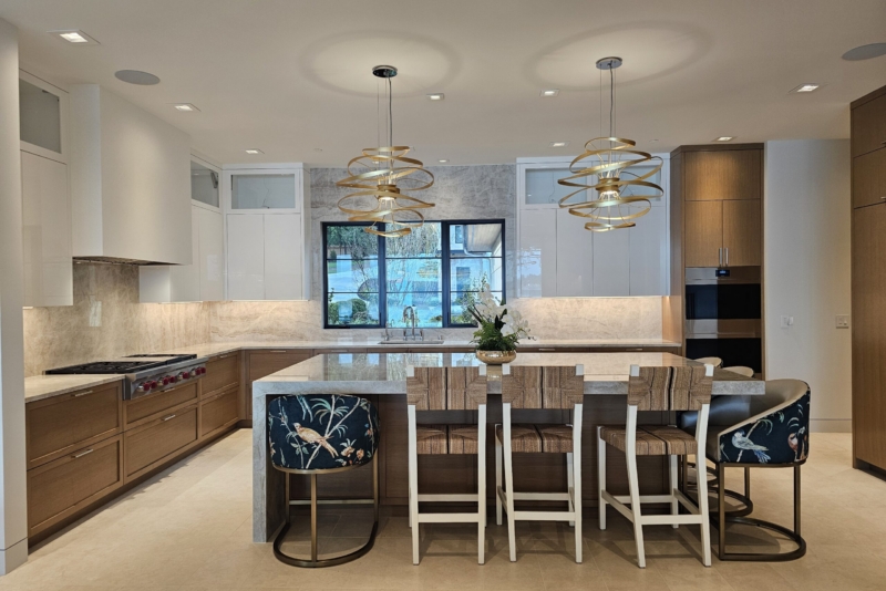 Full kitchen view with quartzite island seating and matching stone backsplash on both walls