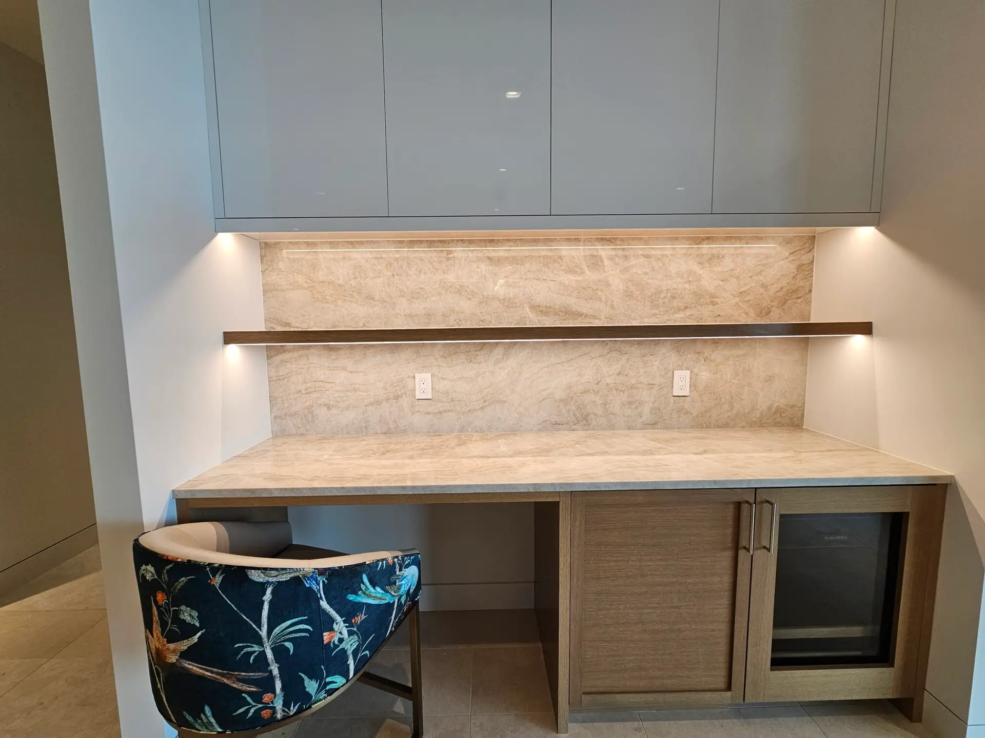 Built-in buffet nook with quartzite counter and backsplash, floating wood shelf, and beverage cooler