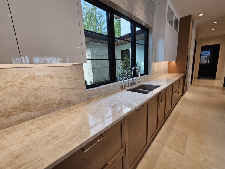 Long run of quartzite countertop and full-height backsplash along the kitchen perimeter
