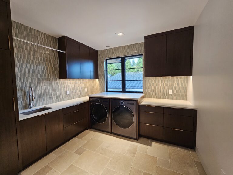 Laundry room with quartz folding counter over the washer and dryer and stacked mosaic backsplash