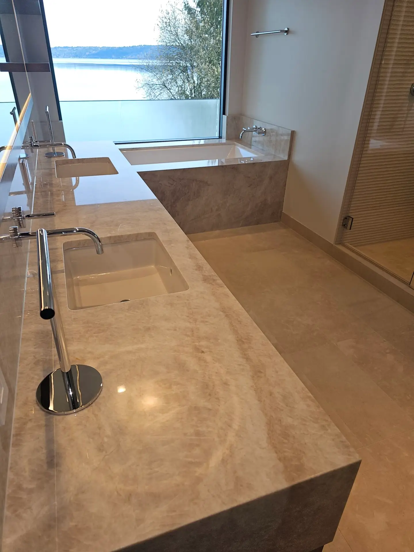Quartzite slab backsplash and wall-mounted faucet detail in the primary bathroom