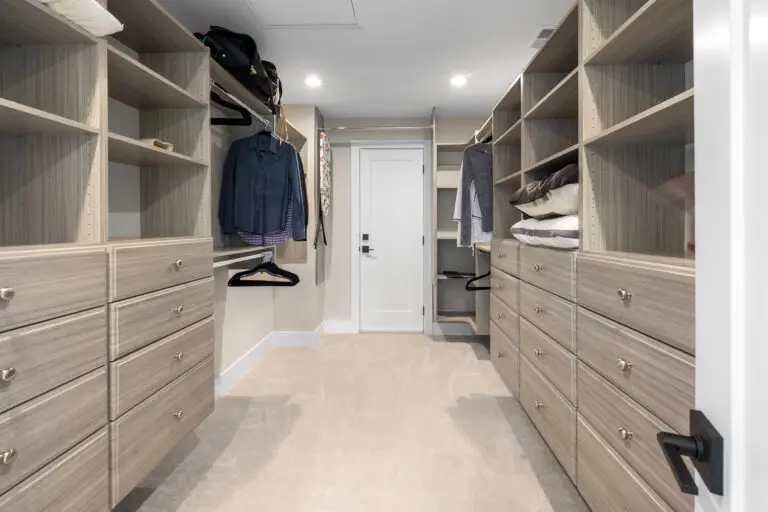 Walk-in closet with custom light wood built-ins, drawer banks, and hanging storage