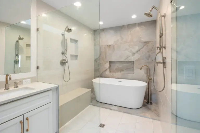 Wet room detail of freestanding soaking tub, floor-mounted tub filler, and marble-look porcelain accent wall