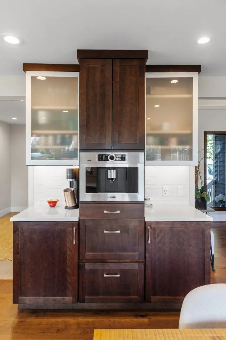 Coffee bar with built-in espresso machine, dark shaker cabinets, white quartz counters, and glass uppers
