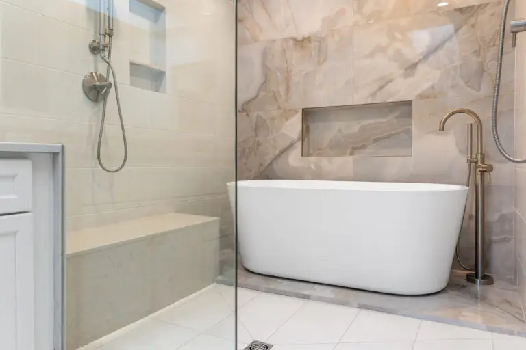 Wet room with freestanding tub, quartz shower bench, handheld sprayers, and marble-look feature wall