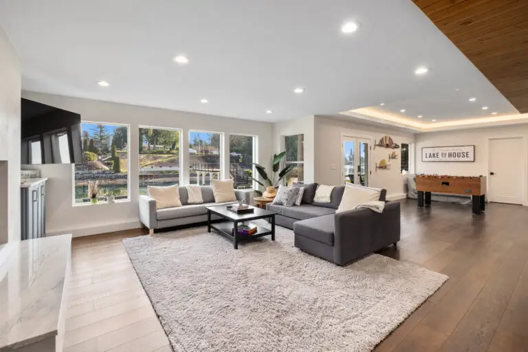Family room with sectional seating, lake house sign, foosball table, and water-view windows