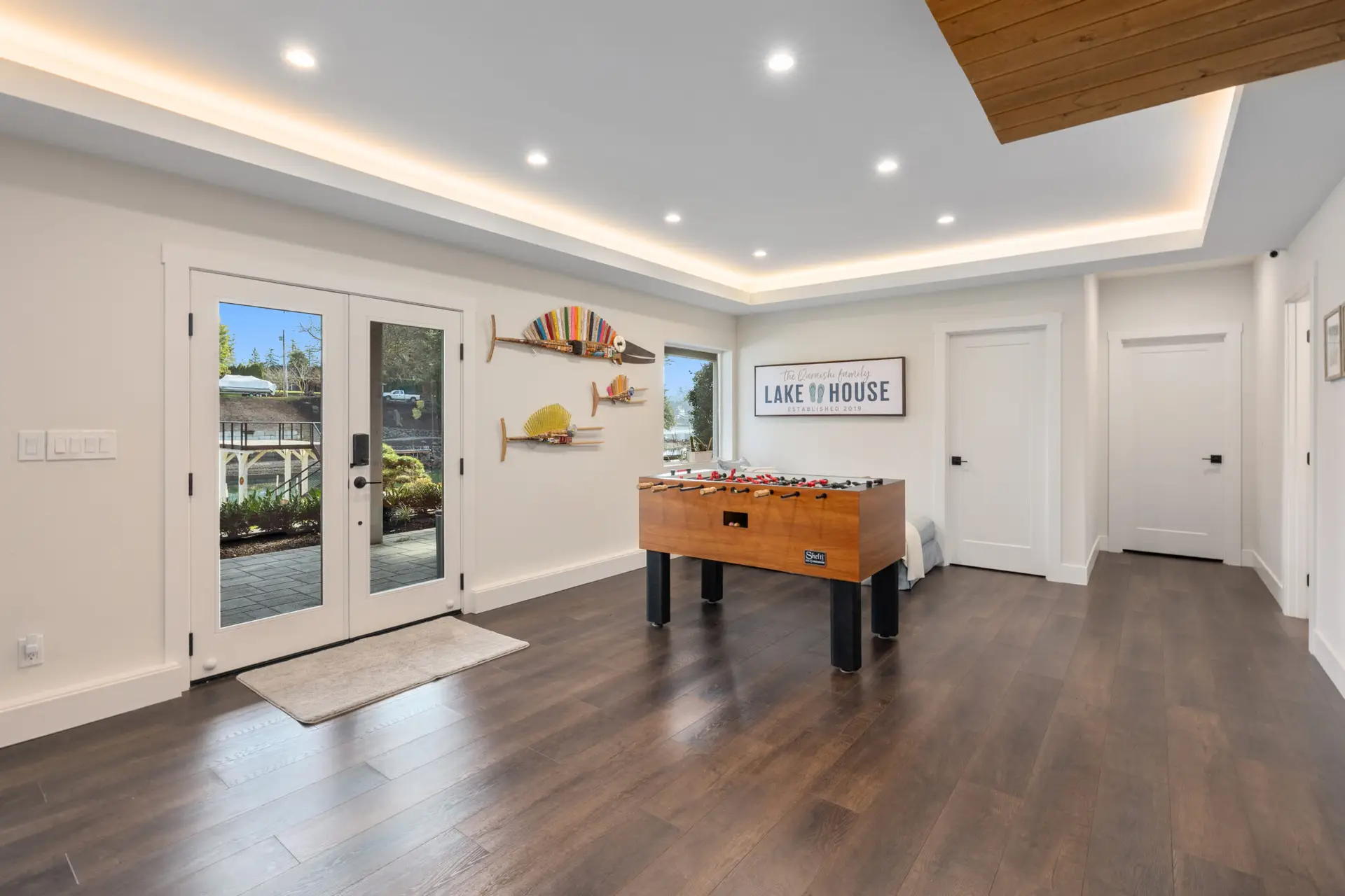 Game area with foosball table, glass french doors to the patio, and tray ceiling with cove lighting