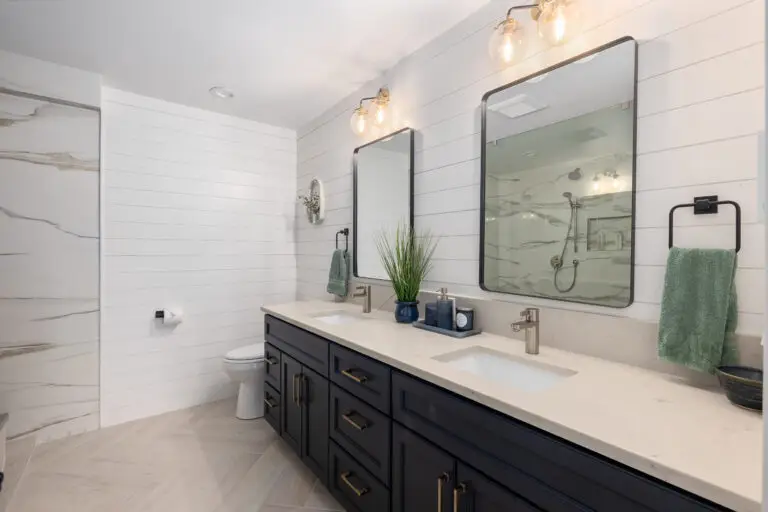 Marble-look porcelain shower walls with dual shower stations, recessed niche, and herringbone tile floor