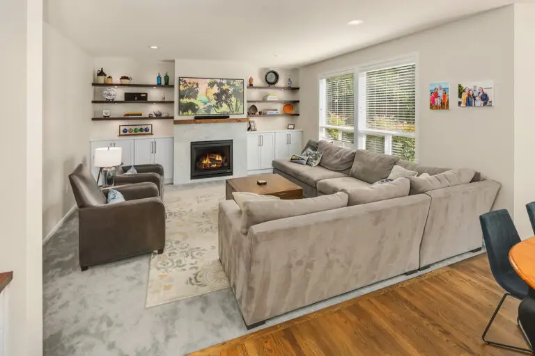 Family room with gas fireplace, marble-look surround, wood mantel, floating shelves, and white built-ins