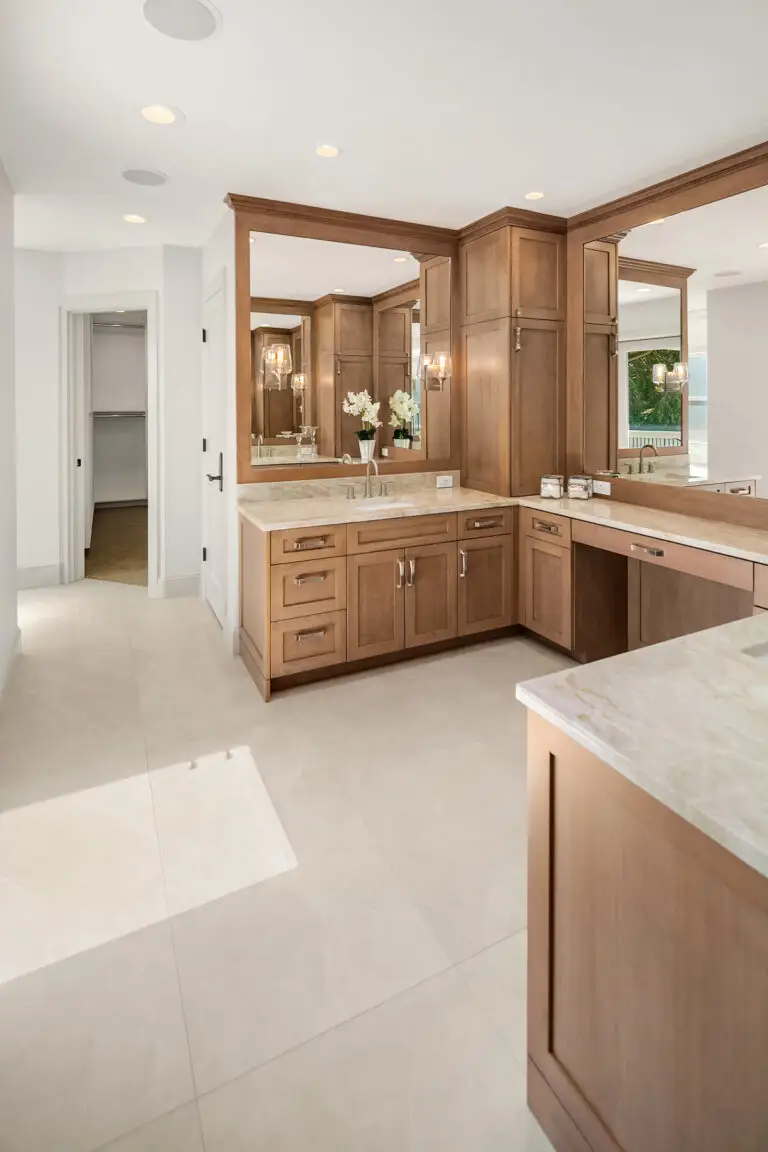 Master bathroom with cherry vanities, Taj Mahal quartzite counters and hallway to the walk-in closet