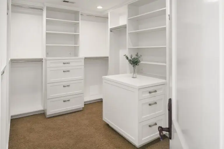 Walk-in closet with white island dresser, open shelving and eucalyptus accent