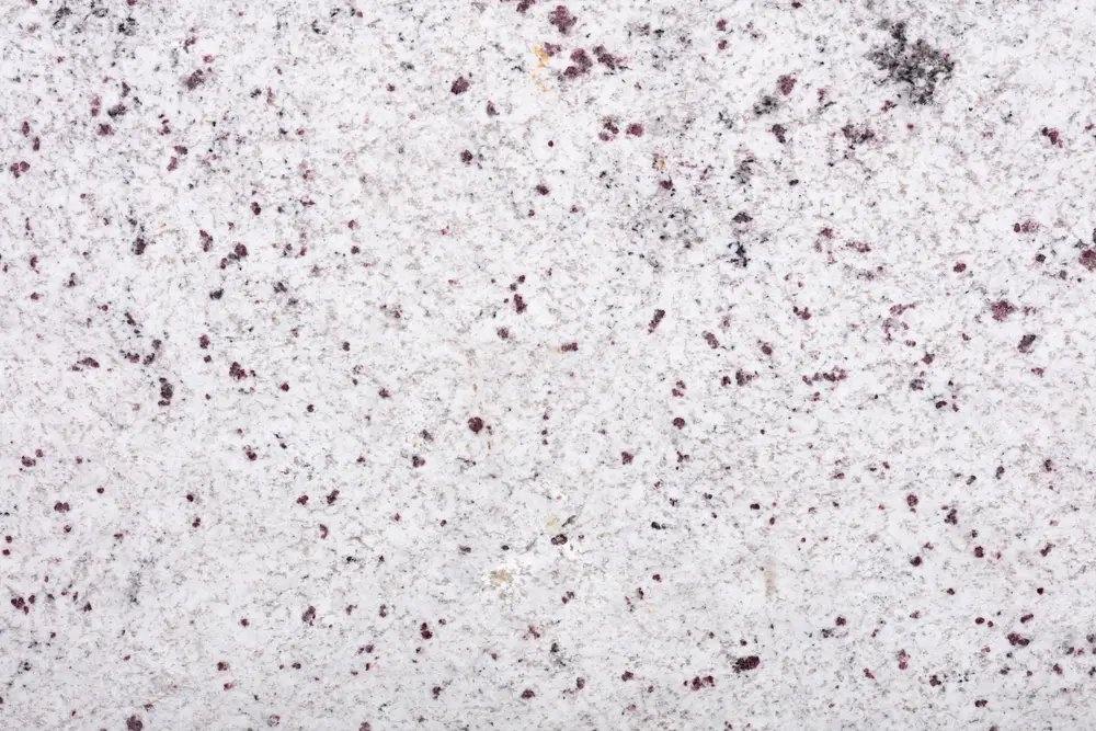 White granite slab with burgundy and black flecks, close-up