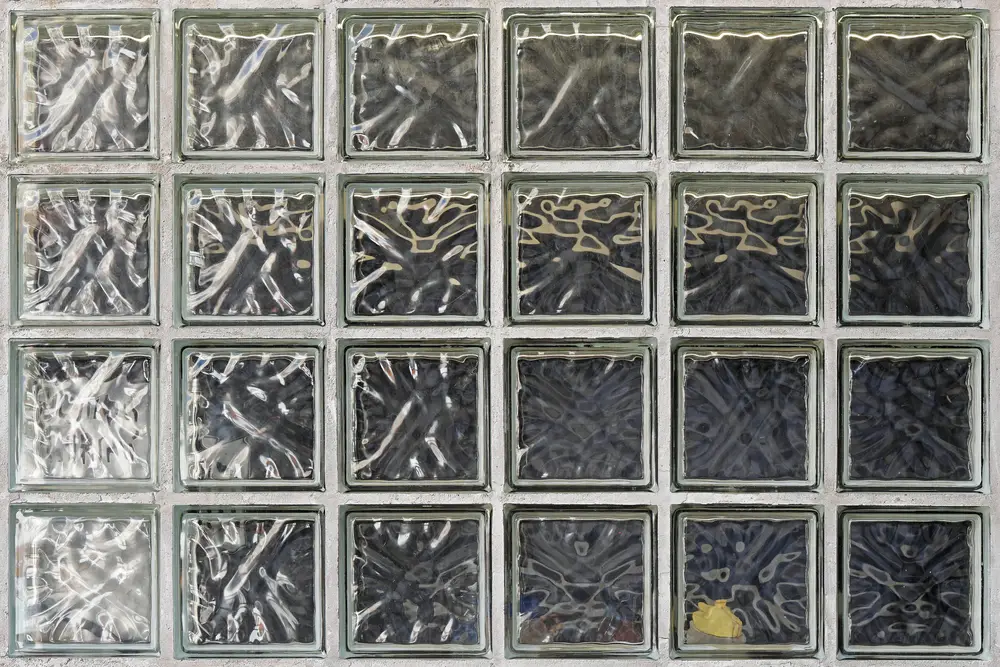 Glass block wall with textured squares in a grid pattern