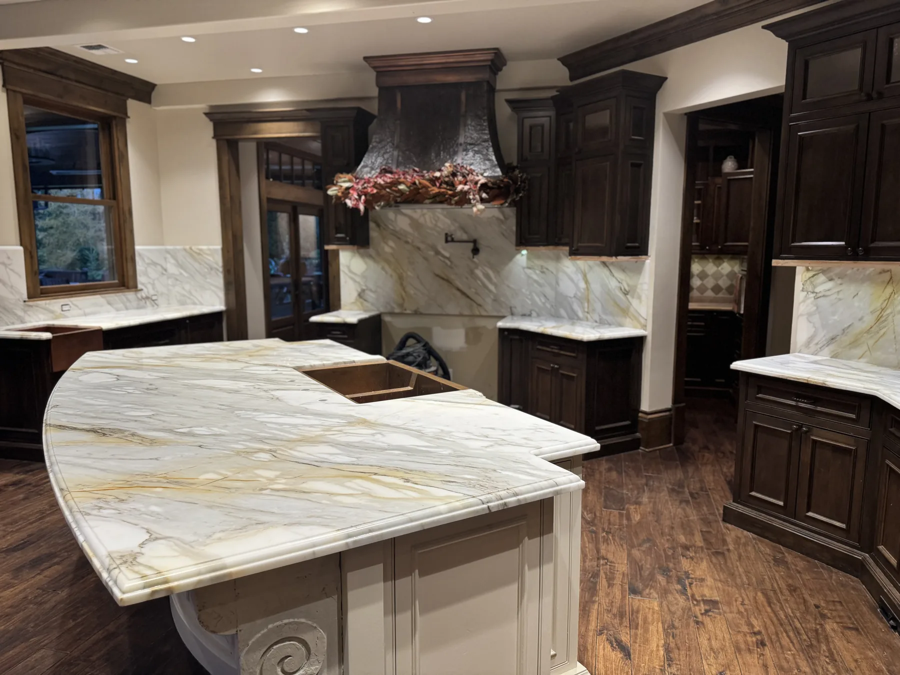 Curved Calacatta Gold marble kitchen island with a Dupont Ogee edge profile