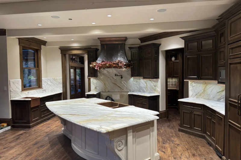 Honed Calacatta Gold marble countertops and full-height backsplash in a Snohomish kitchen with dark walnut cabinetry