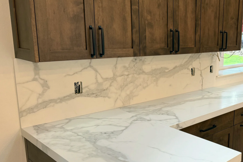 Calacatta Silky porcelain countertops and full-height backsplash with dark stained cabinets in a Woodinville kitchen