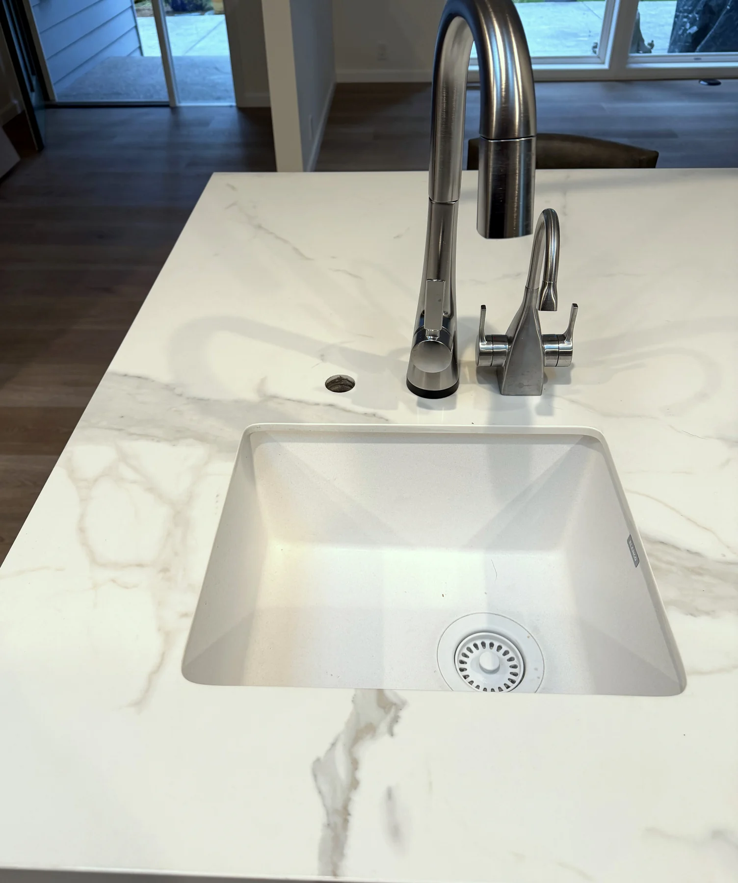 Undermount prep sink set into a Calacatta Silky porcelain kitchen island with soft grey veining.