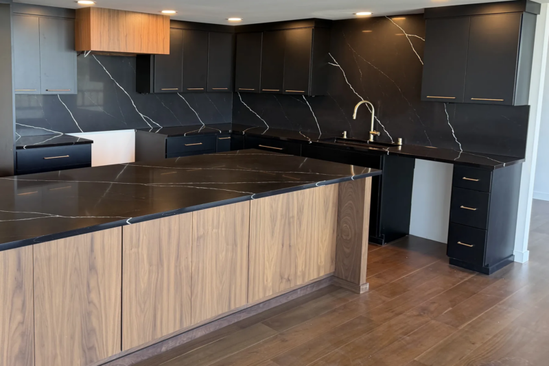 Black Marquina Midnight quartz countertops and seamless full-height backsplash in a Tacoma kitchen with a black walnut island