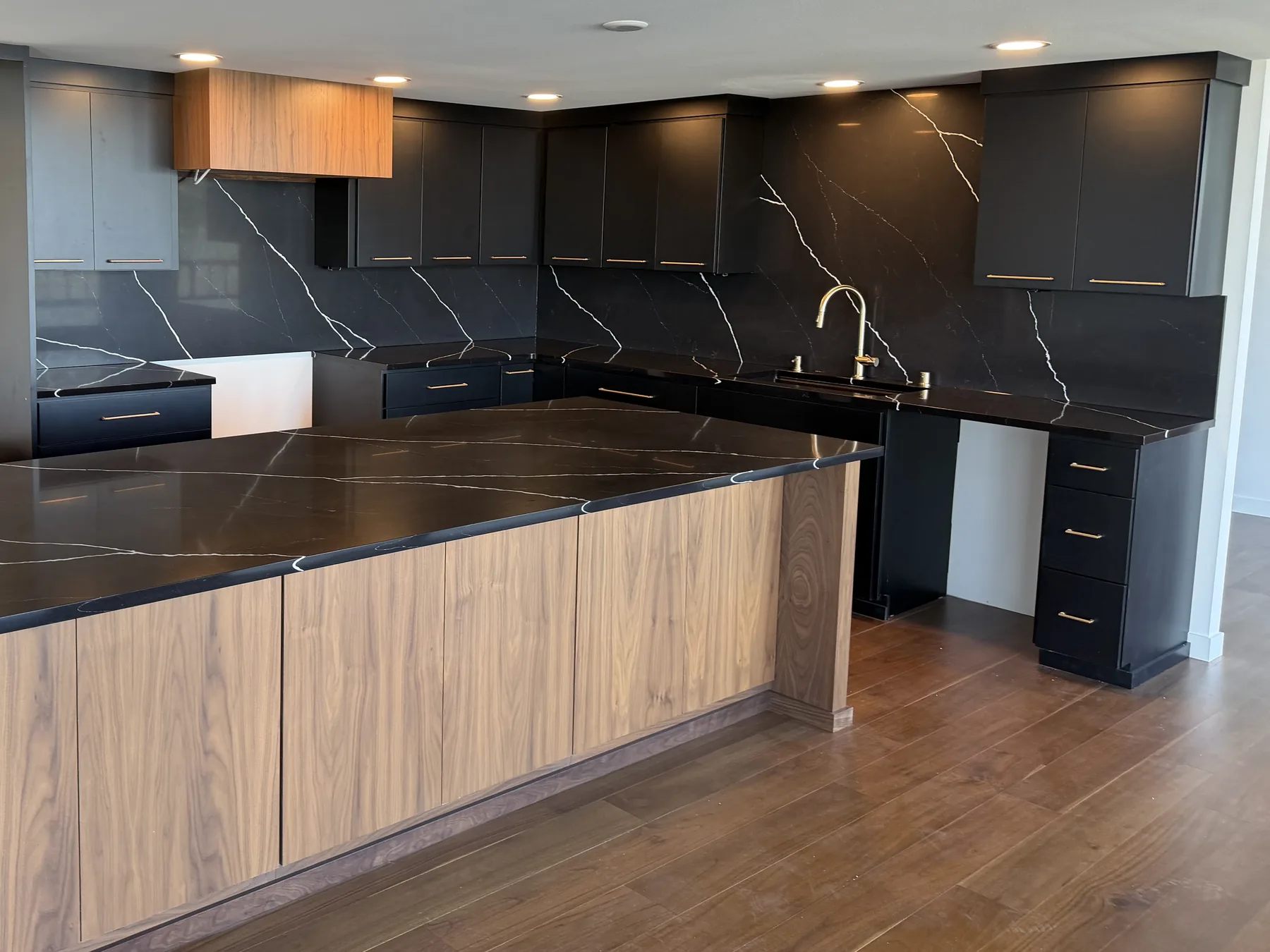 Black Marquina Midnight quartz countertops and seamless full-height backsplash in a Tacoma kitchen with a black walnut island